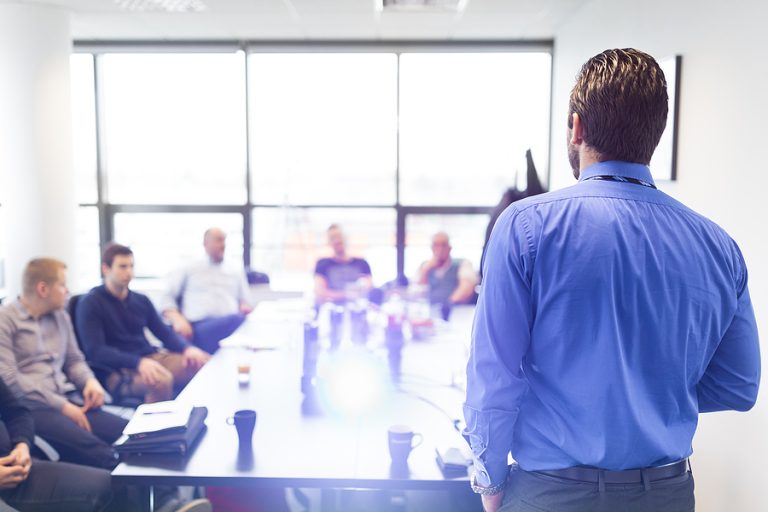 Business executive delivering professional presentation to colleagues during corporate meeting, representing business consulting and legal services in Fort Lauderdale