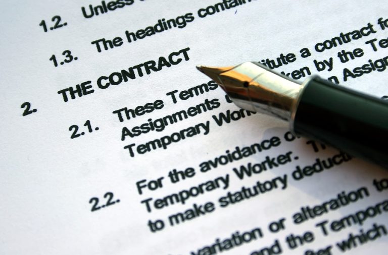 Legal contract document with pen pointing to the words 'The Contract', representing comprehensive legal and insurance services for Fort Lauderdale business clients
