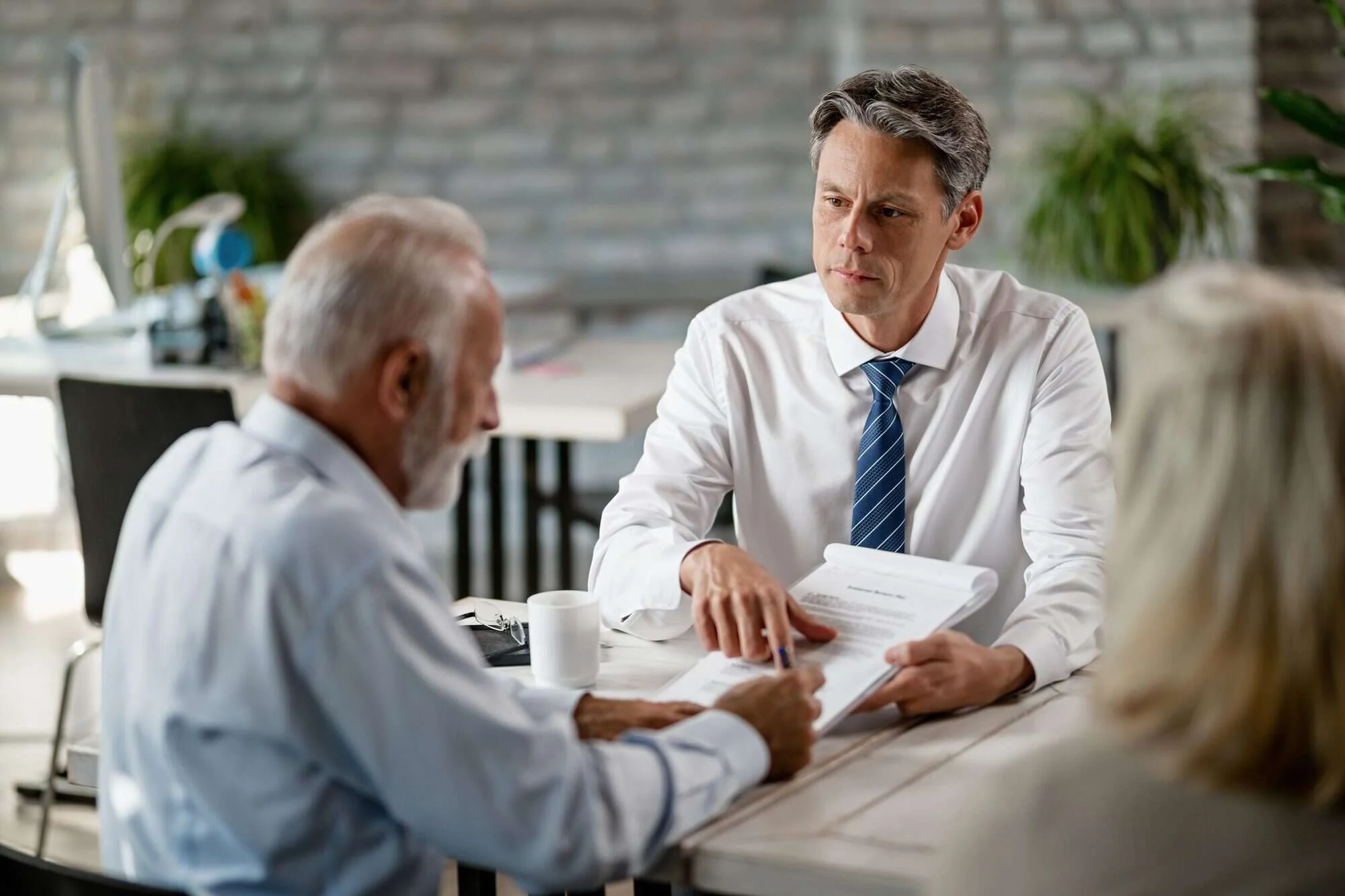 Naples life insurance attorney reviewing claim documents with a beneficiary couple